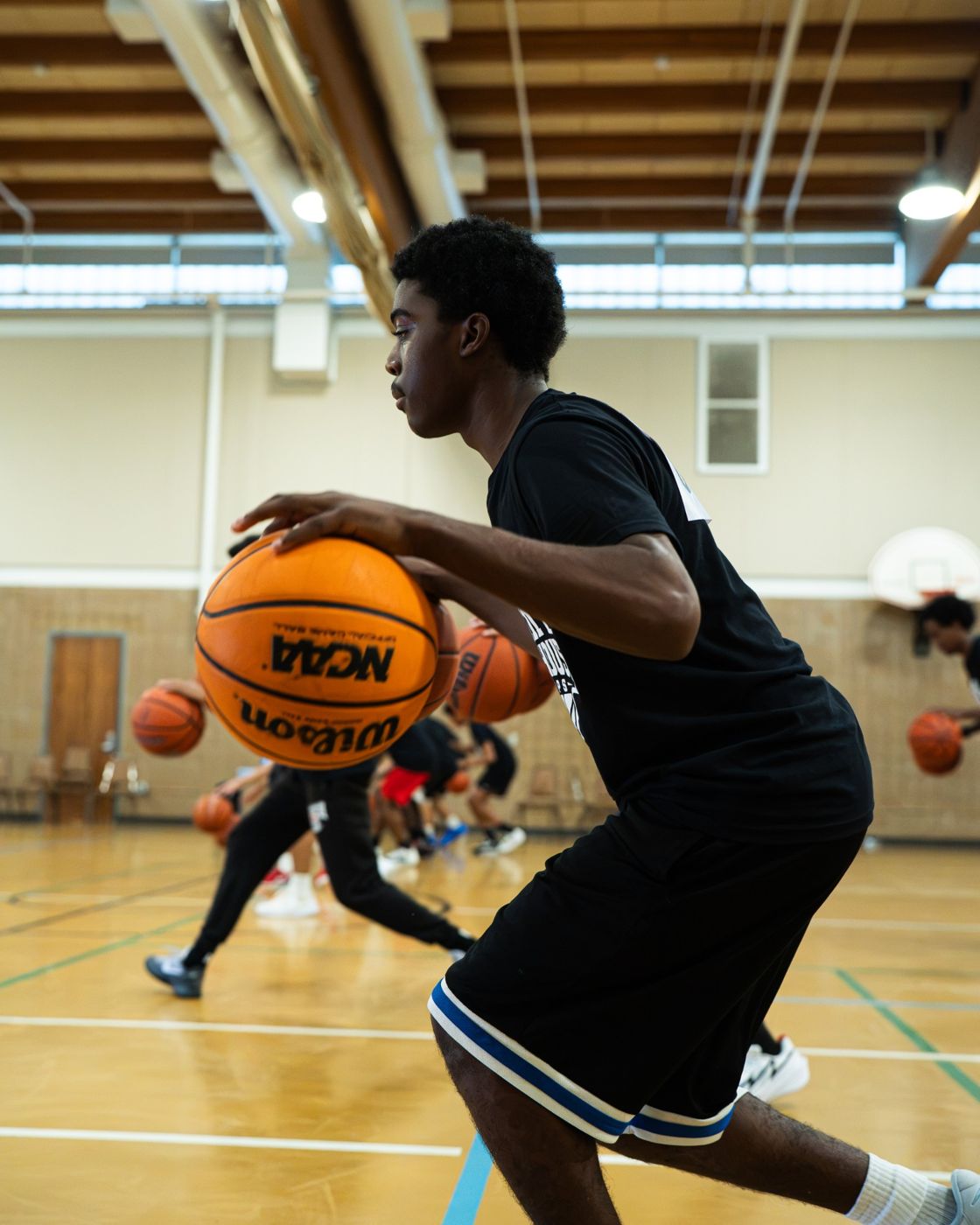 A player dribbling two balls during a drill