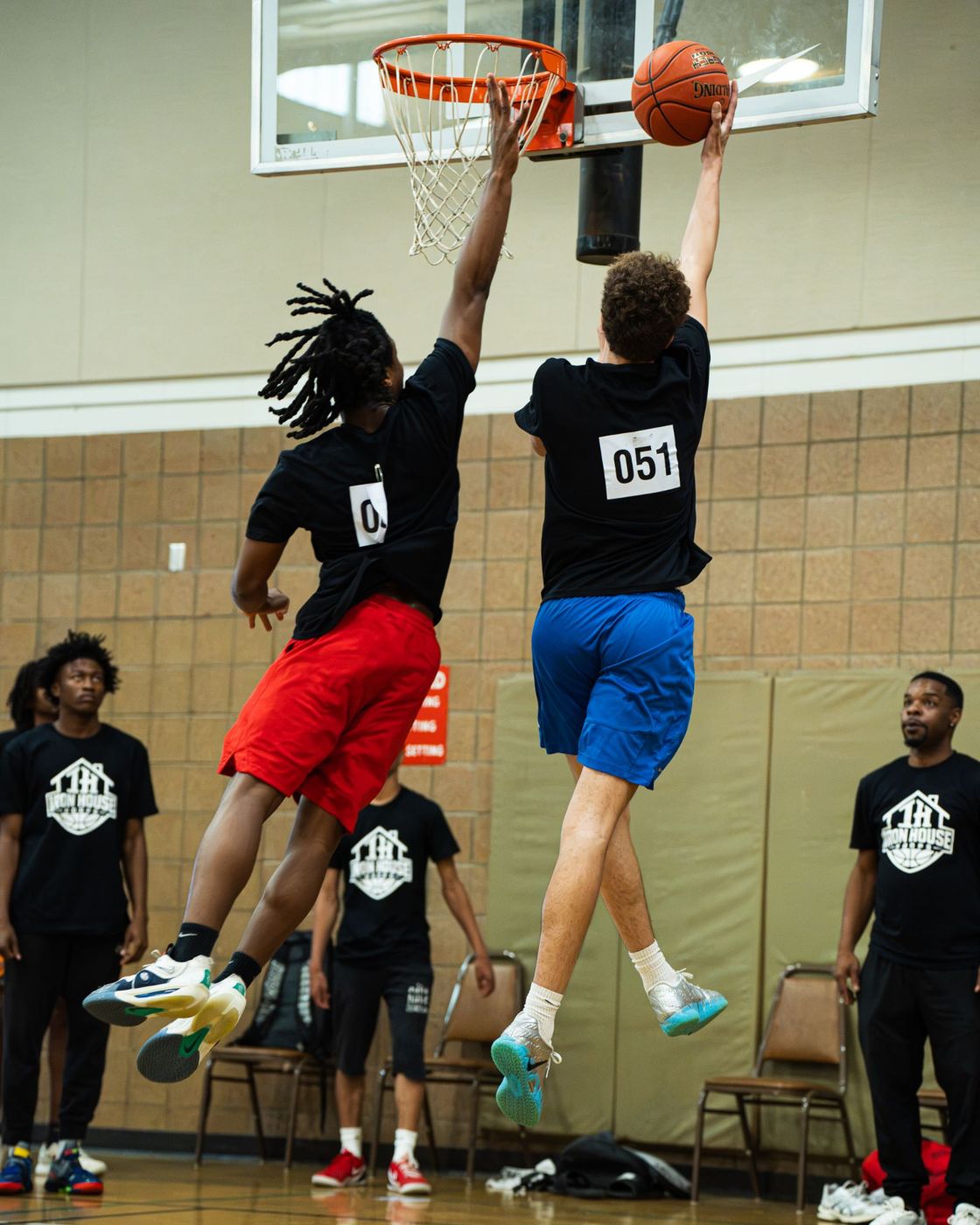 A player finishing at the rim with a defender on him